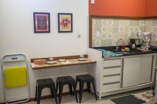 a small kitchen with a counter and stools at Promocional 3 Pessoas Vila Praia do Forte in Mata de Sao Joao