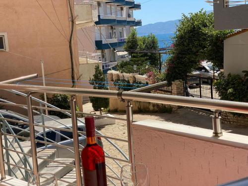 a bottle of wine sitting on a balcony at Olive Tree Apartment in Sarandë