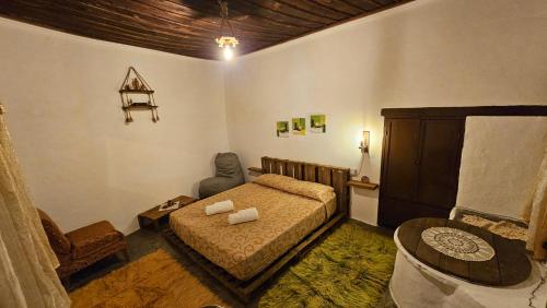a bedroom with a bed and a table and a chair at Guest House Panorama in Berat