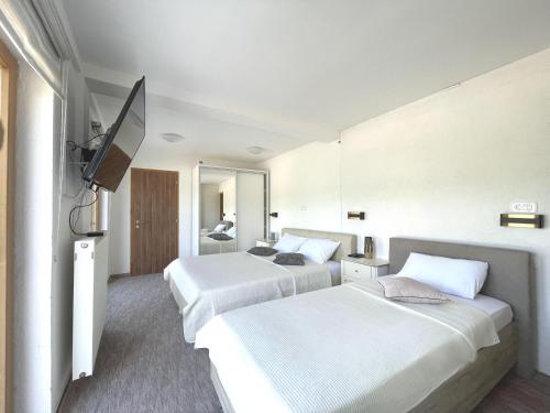 a hotel room with two beds and a flat screen tv at Villa Sarajevo in Vareš