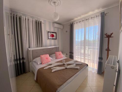 a bedroom with a bed with towels on it at Olive Tree Apartment in Sarandë