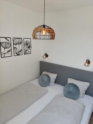 a bed with two blue pillows on top of it at Ferienwohnung ENZIAN - nähe Kapellplatz - öffentlicher Parkplatz - Aufzug in Altötting