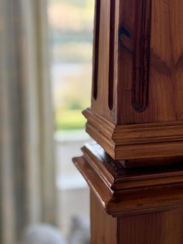 a wooden corner of a wooden table with a window at Dale Head Hall Lakeside Hotel in Keswick