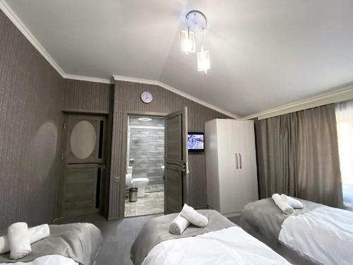 a hotel room with two beds and a bathroom at Qafqaz Resort Wonderland in Gabala