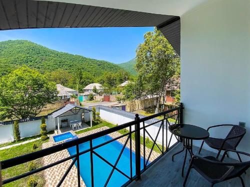 a balcony with a view of a pool and mountains at Qafqaz Resort Wonderland in Gabala