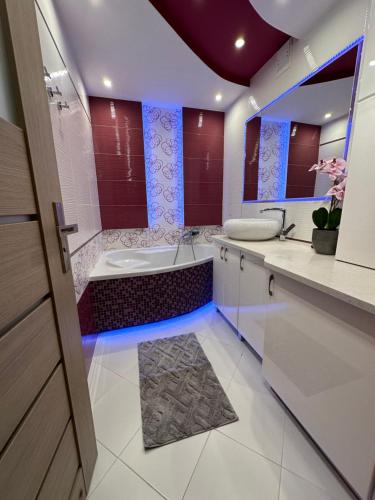 a bathroom with a tub and a toilet and a sink at Large, luxury condo with sauna in Przemyśl
