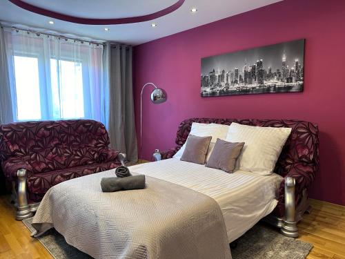 a bedroom with purple walls and a bed and a chair at Large, luxury condo with sauna in Przemyśl