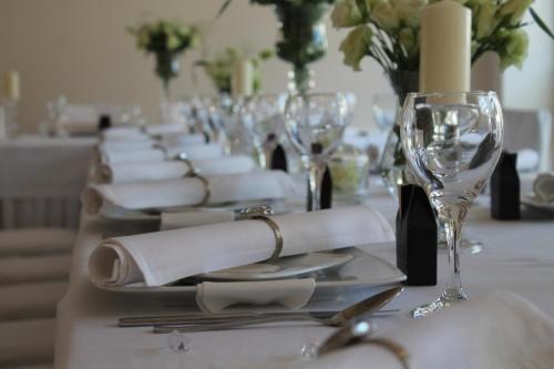 a long table with white plates and wine glasses at Hotel Vitalia in Boszkowo