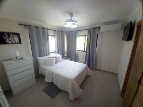 a bedroom with a white bed and a dresser and window at Apartamento con agua caliente para 9 personas in La Ureña