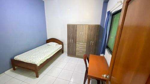 a small bedroom with a bed and a cabinet at Casa Reátegui in Iquitos