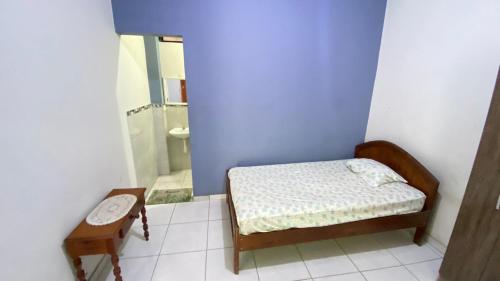 a small bedroom with a bed and a bathroom at Casa Reátegui in Iquitos