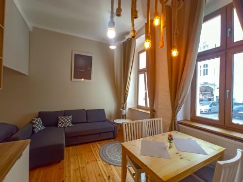ein Wohnzimmer mit einem blauen Sofa und einem Tisch in der Unterkunft Mazurska Apartments in Stettin