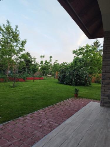 a backyard with a brick walkway and a grass yard at Gönyüi álom kuckó in Gönyů
