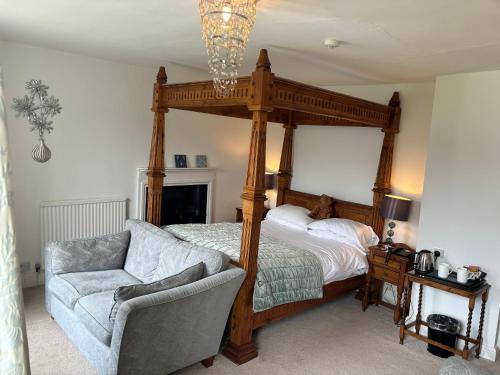 a bedroom with a canopy bed and a chair at Dale Head Hall Lakeside Hotel in Keswick