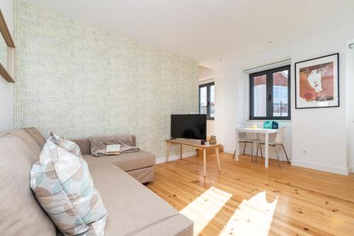 a living room with a couch and a tv at Belem Design Apartments by Homing in Lisbon