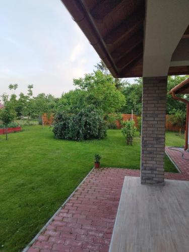 a porch with a brick walkway in a yard at Gönyüi álom kuckó in Gönyů