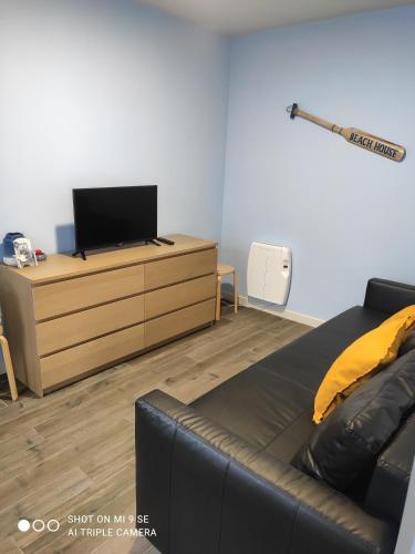a living room with a couch and a tv on a dresser at Yellow Door in Gafanha da Encarnação