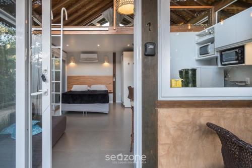 a room with a view of a bedroom with a bed at VGZ - Cabanas charmosas entre Barra de Ibiraquera e Rosa in Imbituba