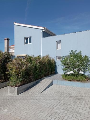 a white building with a tree in front of it at Yellow Door in Gafanha da Encarnação