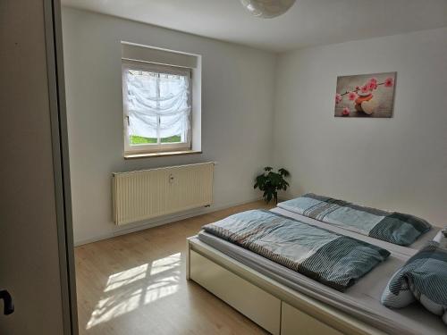 1 dormitorio con cama y ventana en Apartment Home 2, en Schwabach