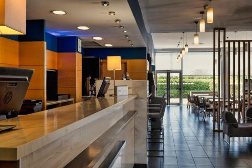 um restaurante com um bar com cadeiras e mesas em Holiday Inn Express Málaga Airport, an IHG Hotel em Málaga