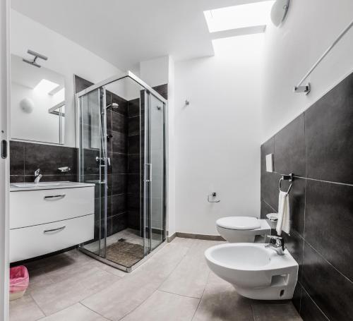 a bathroom with two toilets and a shower and a sink at Magia del Salento in Torre San Giovanni Ugento