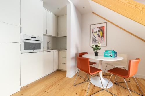 a white kitchen with a table and chairs at Belem Design Apartments by Homing in Lisbon