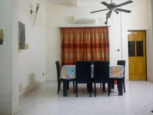 a dining room with a table and chairs and a ceiling fan at BERGET ZACA in Ouagadougou