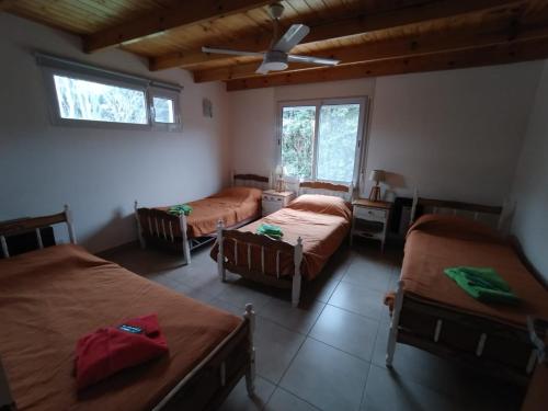 a room with three beds and a ceiling fan at Maika in Sierra de la Ventana