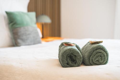 a couple of green towels sitting on a bed at TheServiced - Design Apartments in Stuttgart