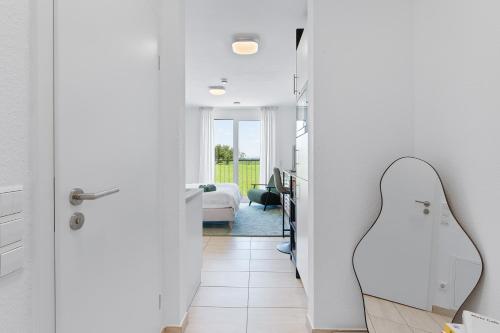 a white hallway with a bedroom and a guitar in a room at The Serviced - Design Apartments in Stuttgart