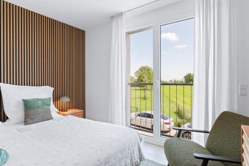 a bedroom with a bed and a large window at TheServiced - Design Apartments in Stuttgart