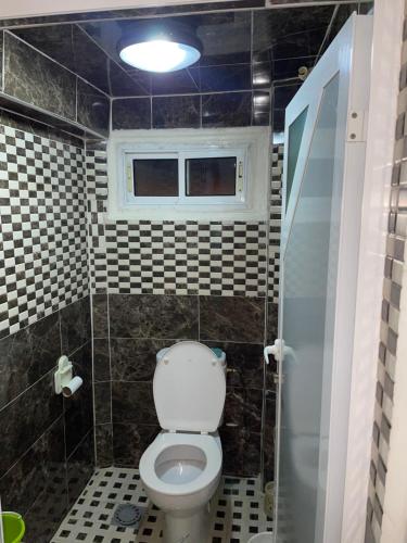 a bathroom with a toilet and a window at maison souk agadir in Agadir
