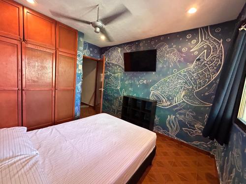 イスラ・ムヘーレスにあるCasa vacacional channel de A.M.k.A.Mのベッドと壁に絵が飾られた寝室