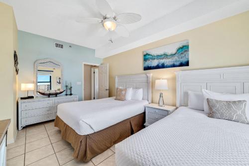 a bedroom with two beds and a mirror at Phoenix 5 Unit 1417 in Orange Beach