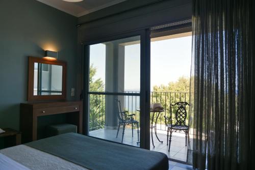 een slaapkamer met een bed en een balkon met uitzicht bij Dalasvillas SkalaMare in Skála Kefalonias