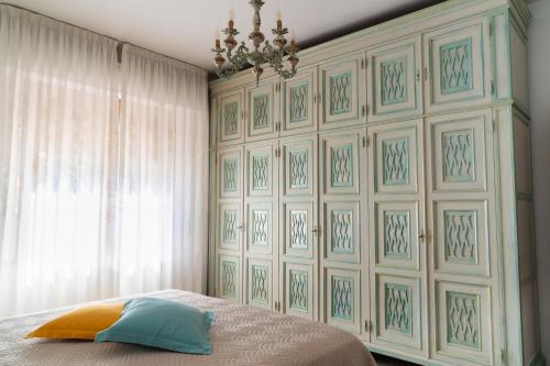a bedroom with a wall with a bed and a chandelier at Casa Italia - Appartamento con giardino e cortile privato in Sinalunga