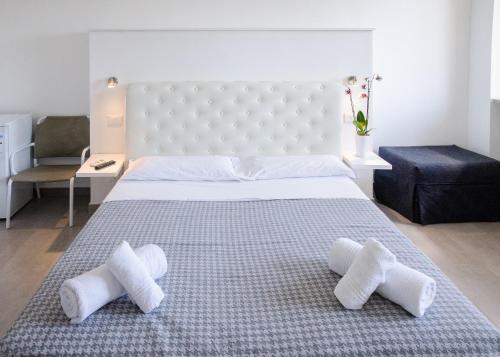 ein Schlafzimmer mit einem großen weißen Bett mit drei Kissen in der Unterkunft Magia del Salento in Torre San Giovanni Ugento