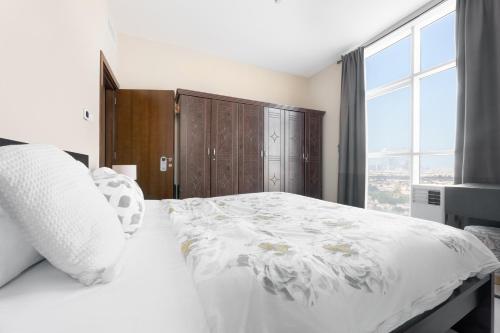1 dormitorio con cama blanca y ventana grande en Great Gatsby's Home en Dubái