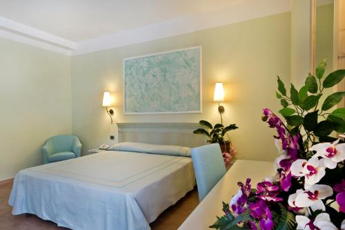 a bedroom with a bed and a table with flowers at Hotel Brancamaria in Cala Gonone