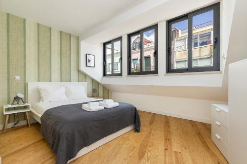 a bedroom with a bed and two windows at Belem Design Apartments by Homing in Lisbon