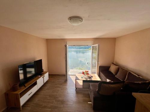 a living room with a couch and a television at Lakeside Harmony Apartment in Golubovci
