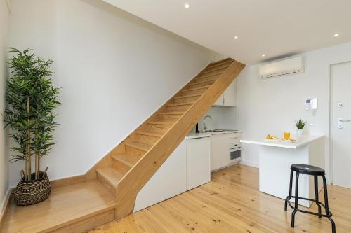 a staircase in a kitchen with white walls and wooden floors at Belem Design Apartments by Homing in Lisbon