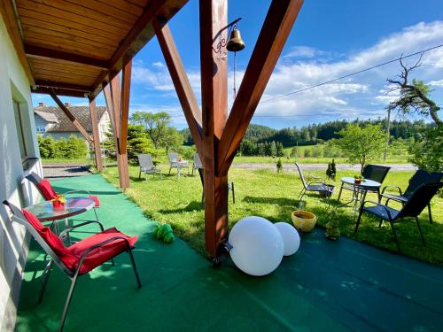 a patio with chairs and a table with a view of a field at Penzion Patriot in Výprachtice