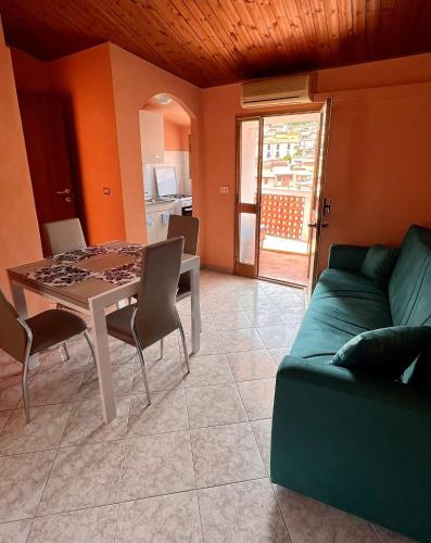 a living room with a table and a green couch at La casa storica in Santu Lussurgiu