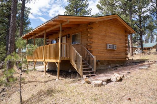 a log cabin in the woods with a deck at Rock Crest Lodge & Cabins in Custer