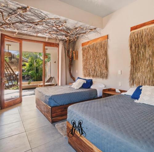 a hotel room with two beds and a balcony at Mare mío Hotel Boutique in Puerto Arista