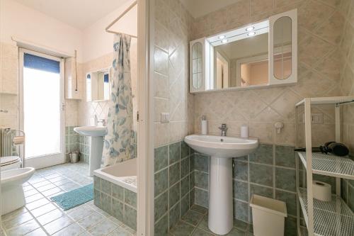 La salle de bains est pourvue d'un lavabo, de toilettes et d'une baignoire. dans l'établissement AmoRoma Holiday, à Rome