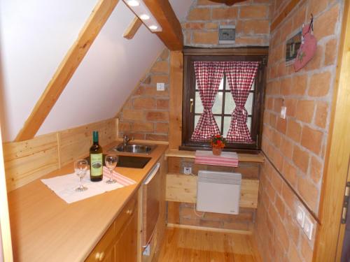 a kitchen with a sink and wine glasses on a counter at APARTMANI Etno kuća pod Okićem in Samobor