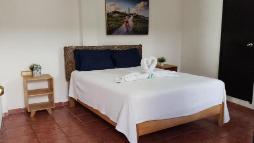 una camera da letto con un letto con lenzuola bianche e un dipinto di Hotel Masam Isla Mujeres a Isla Mujeres